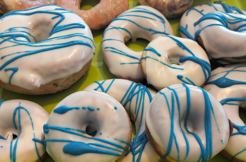Donuts aus dem Donut-Maker und der Heißluftfritteuse mit weißer Glasur und blauen Streifen